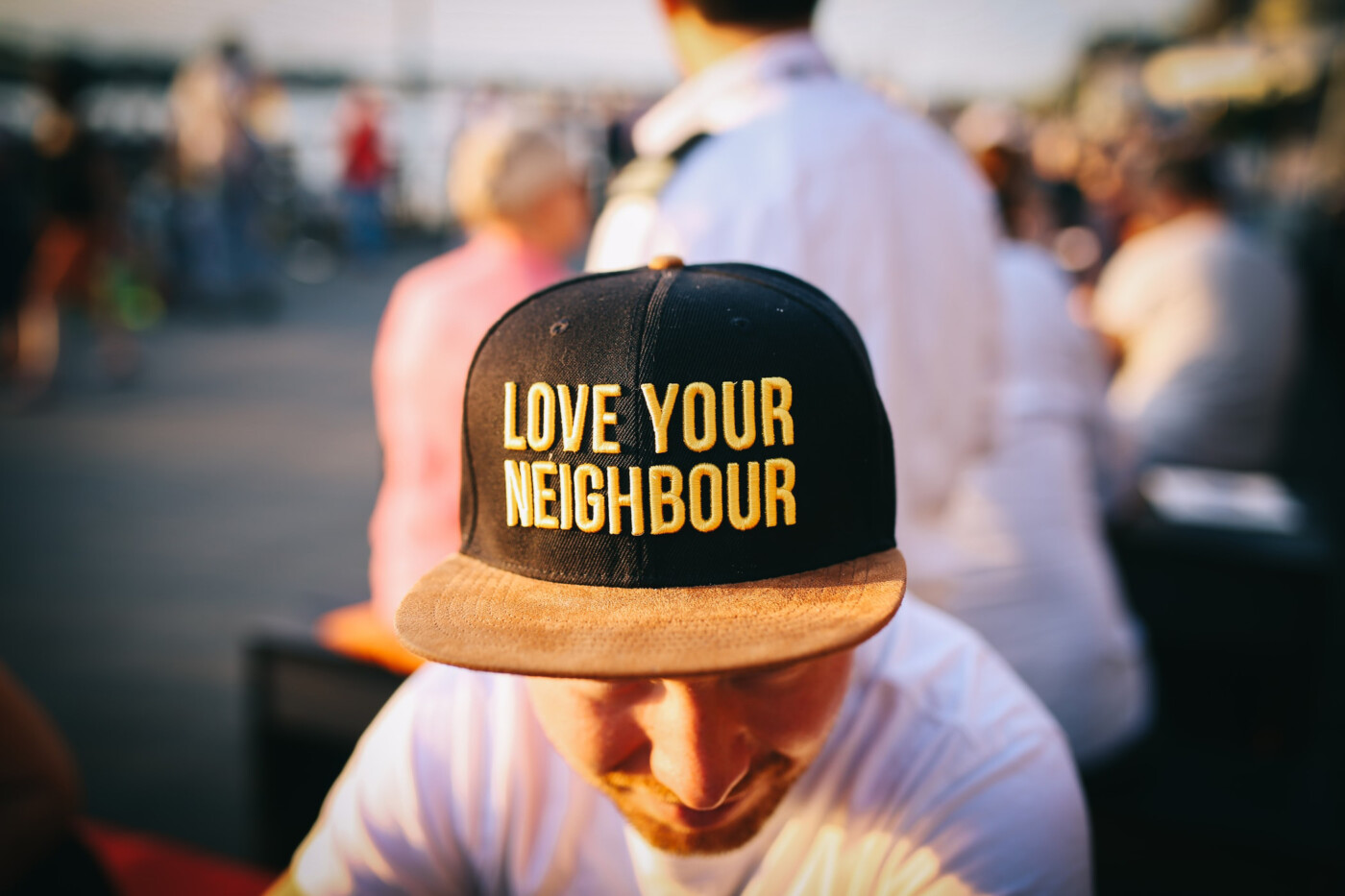 Man med keps med texten Love your neighbour